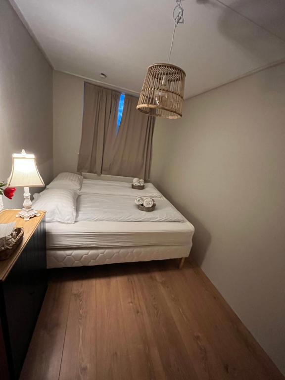 a bedroom with a bed with a chandelier at Cozy room in Stykkishólmur