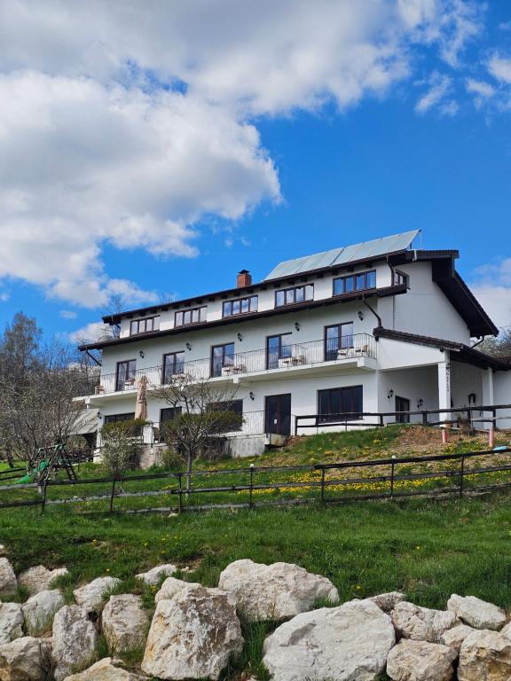 a large white building on a hill with rocks at Belvedere Chalet Bran in Bran