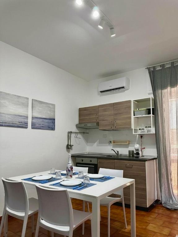 a kitchen with a white table and chairs in a room at Casa Tropea Vibes in Tropea