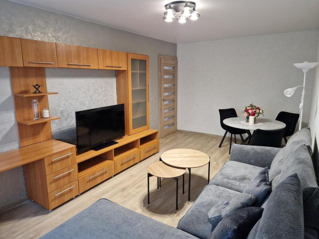 a living room with a couch and a tv and a table at Cozy 3 room appartment in Klaipėda