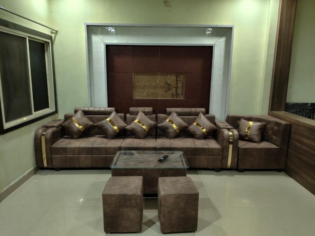 a living room with a brown couch and a table at Avs Jain's house in Ujjain