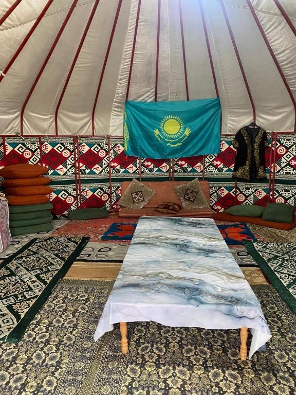 a tent with a couch with a flag on it at Murat Lyazzat Hotel in Kurmenty
