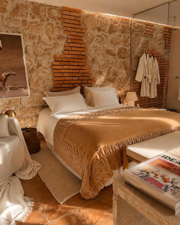 a bedroom with a large bed and a brick wall at Super Galleria - Borgo Stays in Tuscania
