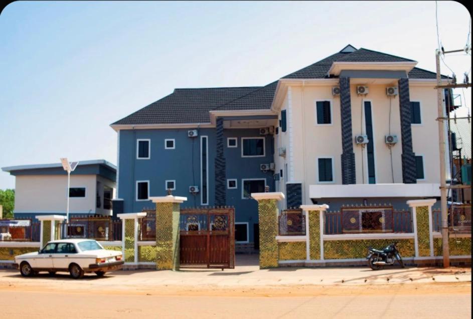 a blue and white house with a car in front of it at Jiksonodohotel in Nsukka