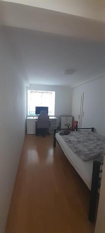 a bedroom with a bed and a desk and a window at Ela Gar 1 WG Zimmer Wohngemeinschaft in Garsten