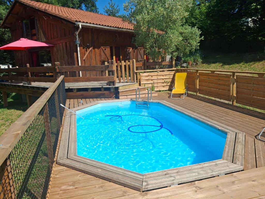 a swimming pool on a wooden deck with a house at Le Refuge De L'Ourse in Anla