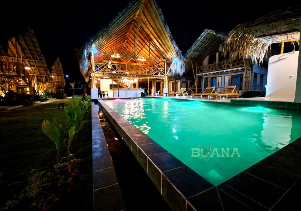 a swimming pool in front of a building at night at Boana hotel in Palomino