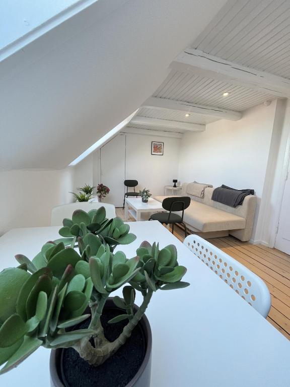 a living room with a plant on a table at Bright and central city apartment near Aalborg Bus in Aalborg