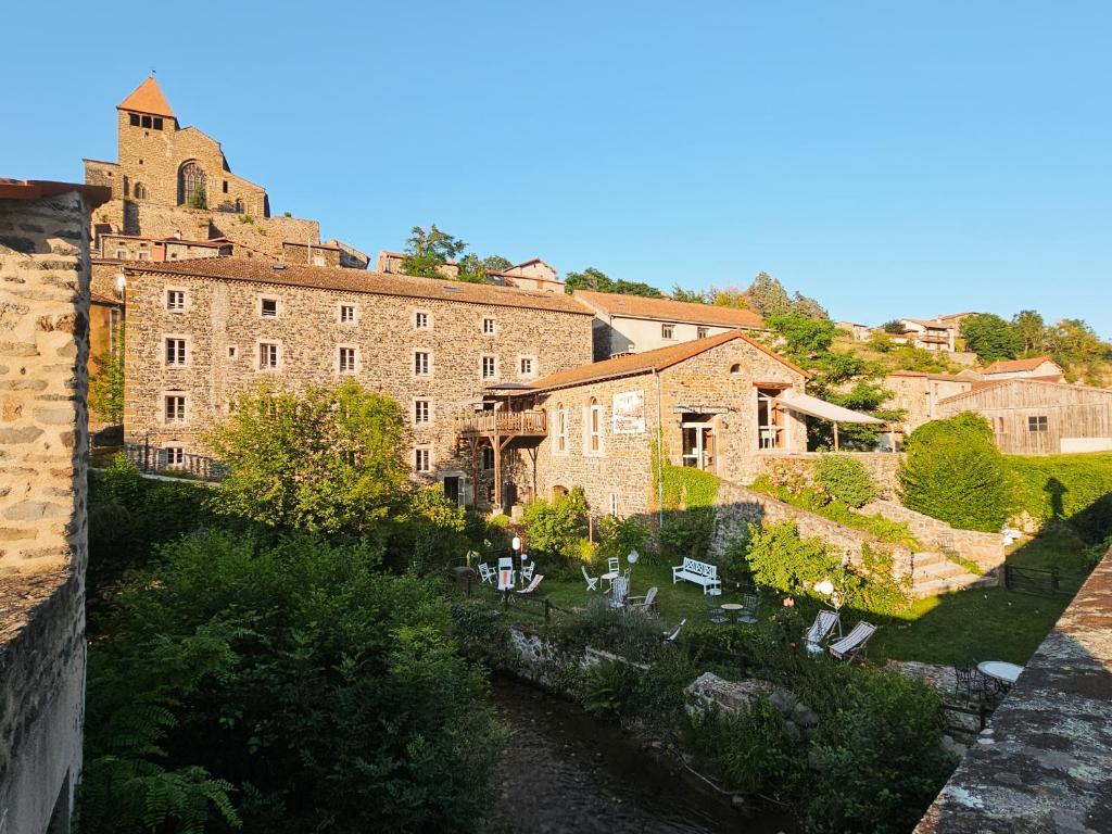 an old building with a garden in front of it at Auberge de Chanteuges in Chanteuges