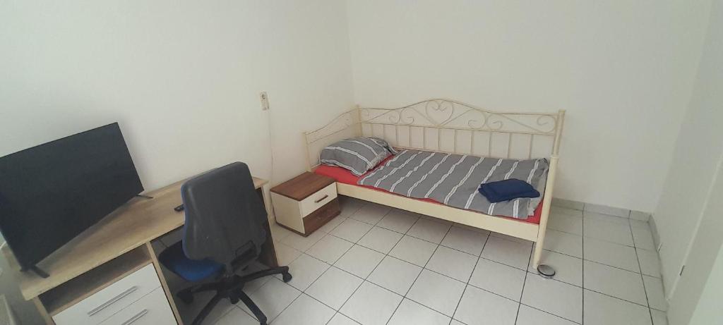 a small bedroom with a bed and a desk with a computer at Ela Gar 6 WG Zimmer in Garsten