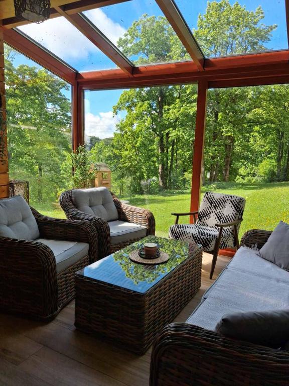 a screened in porch with wicker chairs and a table at Green Forest in Žabljak