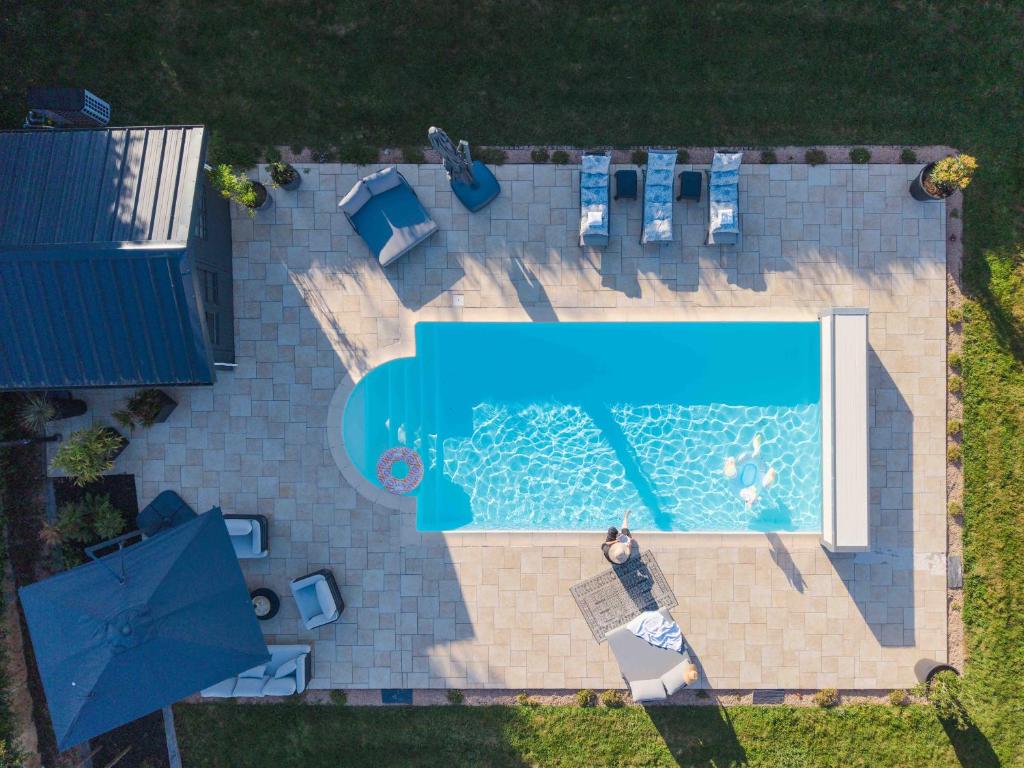 an overhead view of a swimming pool with chairs and a pool at Les Tilleuls de Marie in Saint-Edmond