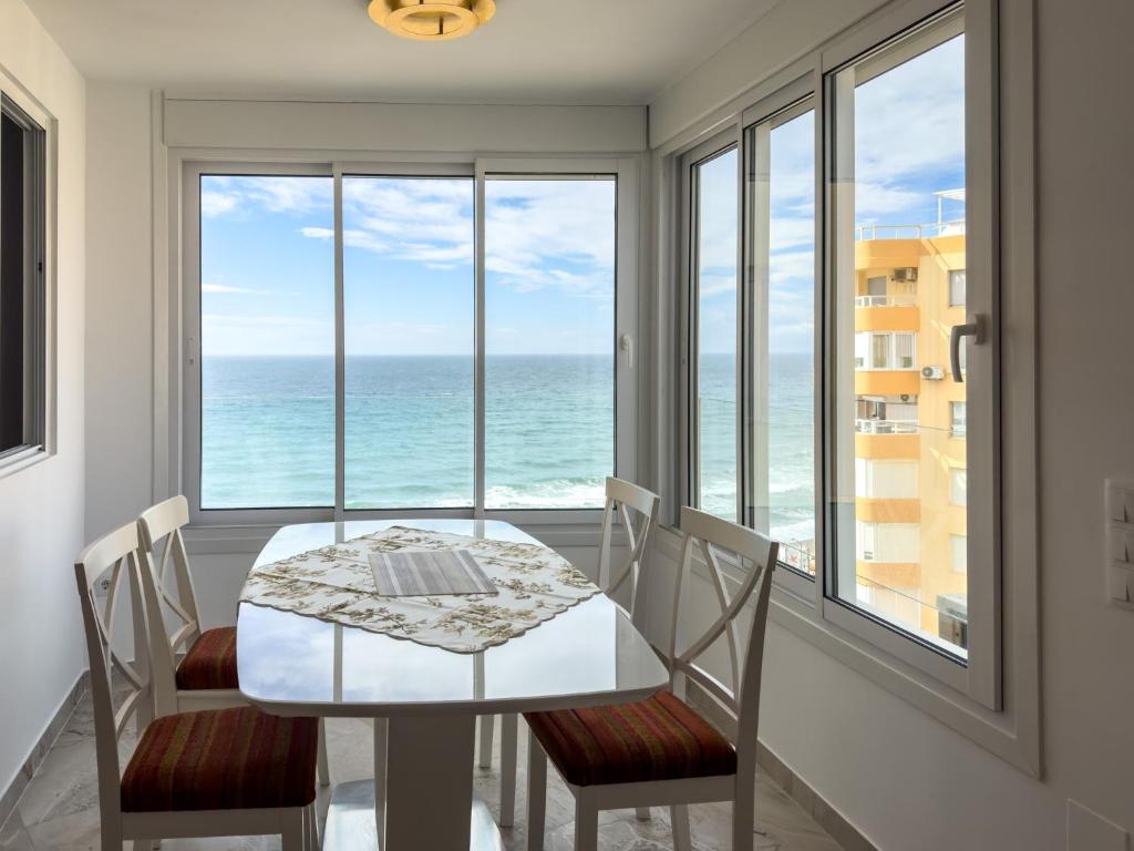 a dining room with a table and chairs and the ocean at Increíbles vistas al mar A102 in Torrox Costa