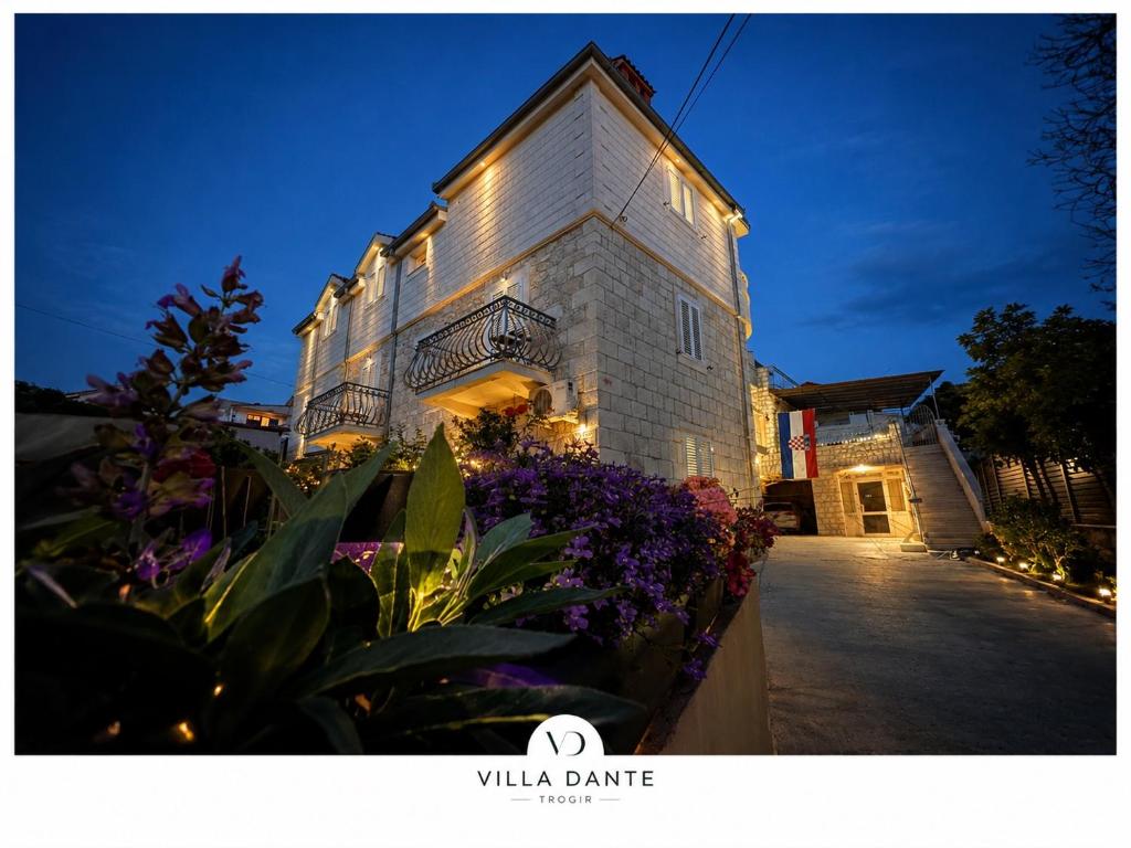 a building with some flowers in front of it at Villa Dante with swimming pool in Trogir
