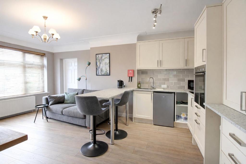 a kitchen and living room with a table and a couch at Greenfields Apartment in Chester