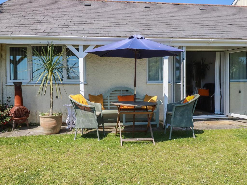 a table and chairs with an umbrella on a house at Rollies Retreat in Fowey