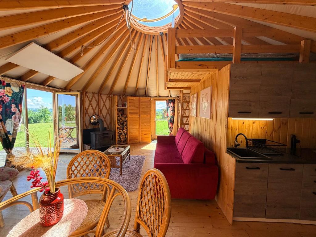 a living room with a couch and a table and chairs at Glamping Niebiańska Osada Jurty Dolnośląskie in Polanica-Zdrój