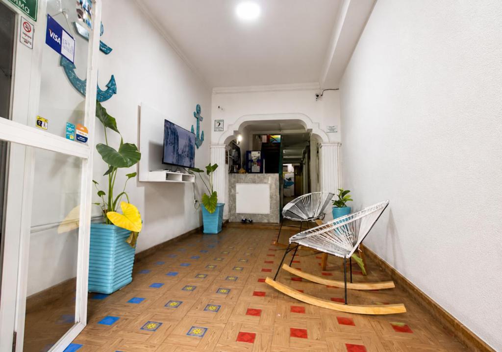 a hallway with two chairs and a table in a room at Ocean Blue Centro Histórico Hotel in Santa Marta