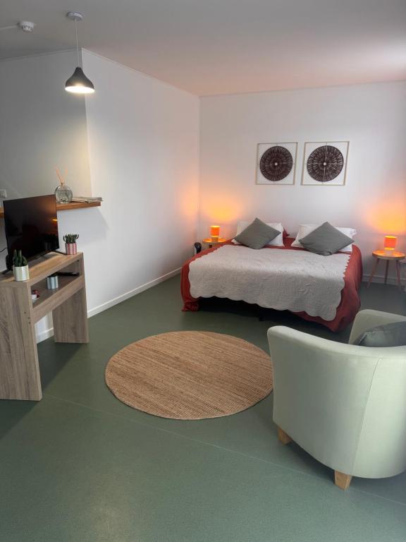a bedroom with a bed and a couch and a table at Studio Les écuries de la forêt in Le Buisson Genois