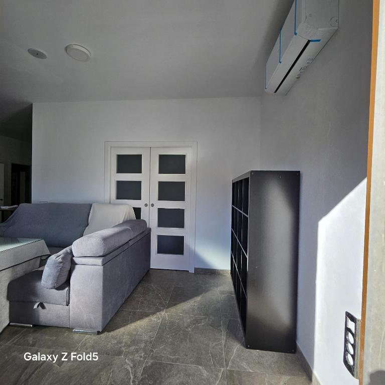 a living room with a couch and a tv at Aires de Benatae in Benatae