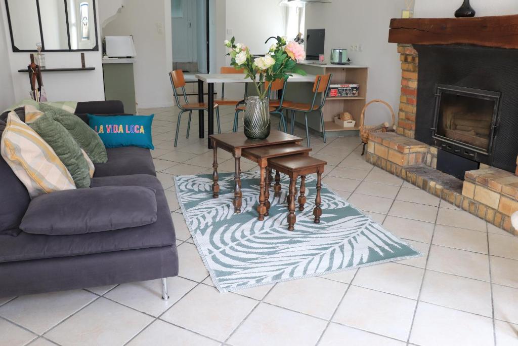 a living room with a couch and a table with flowers at M28 - Maison de campagne avec climatisation in Barby