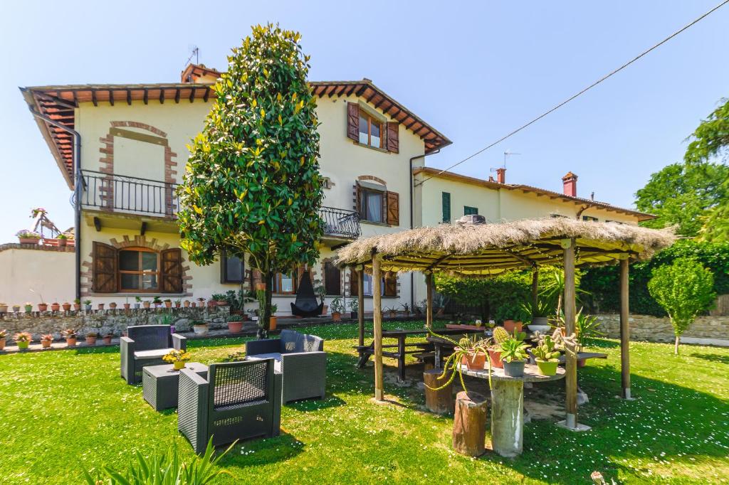 a house with a garden with a table and a umbrella at Casa Aloe B&B in Monte San Savino