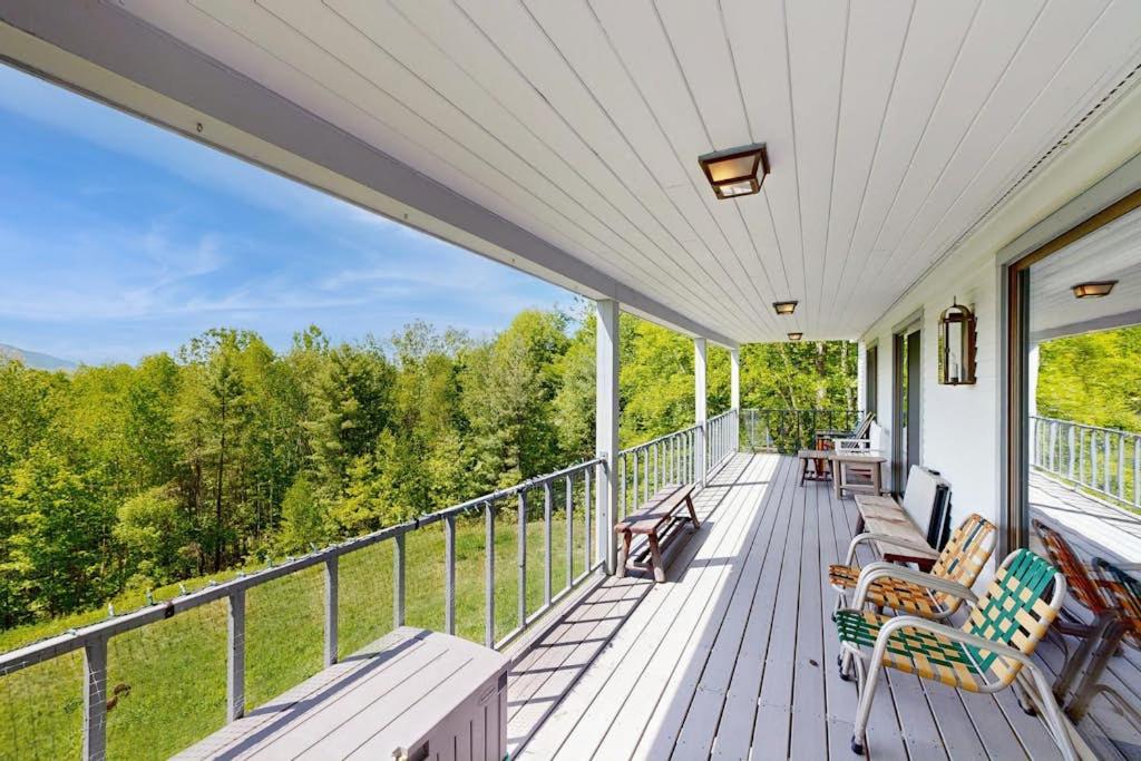 a porch with rocking chairs and a view of the woods at GOPI Notch in Franconia