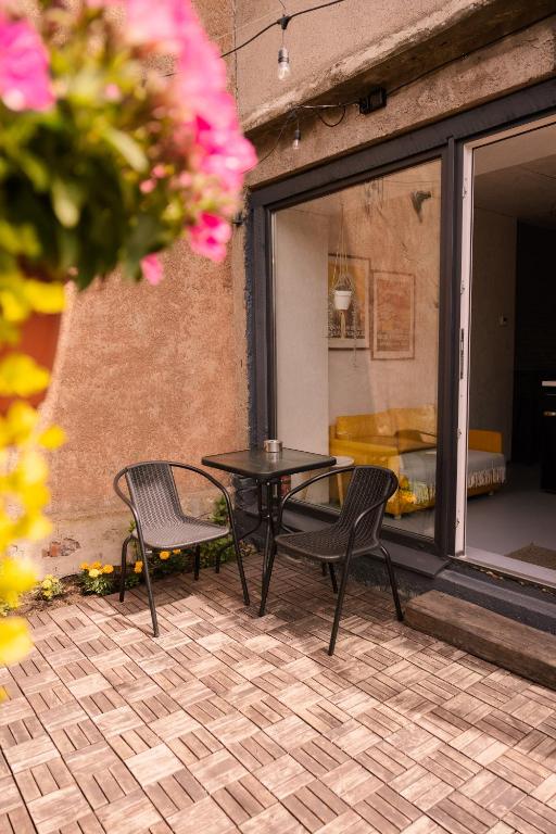 a patio with a table and chairs and a couch at Liepaja Garden Studio with Terrace in Liepāja