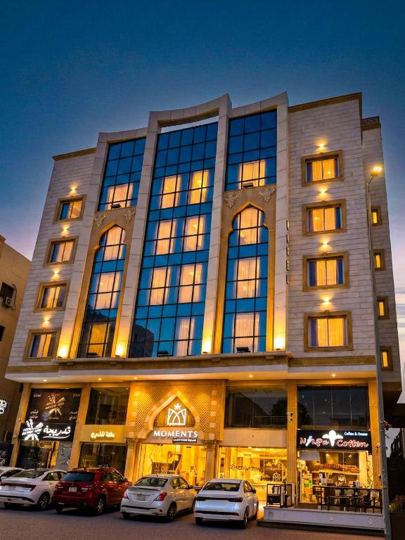 a large building with cars parked in front of it at Moments in Jeddah