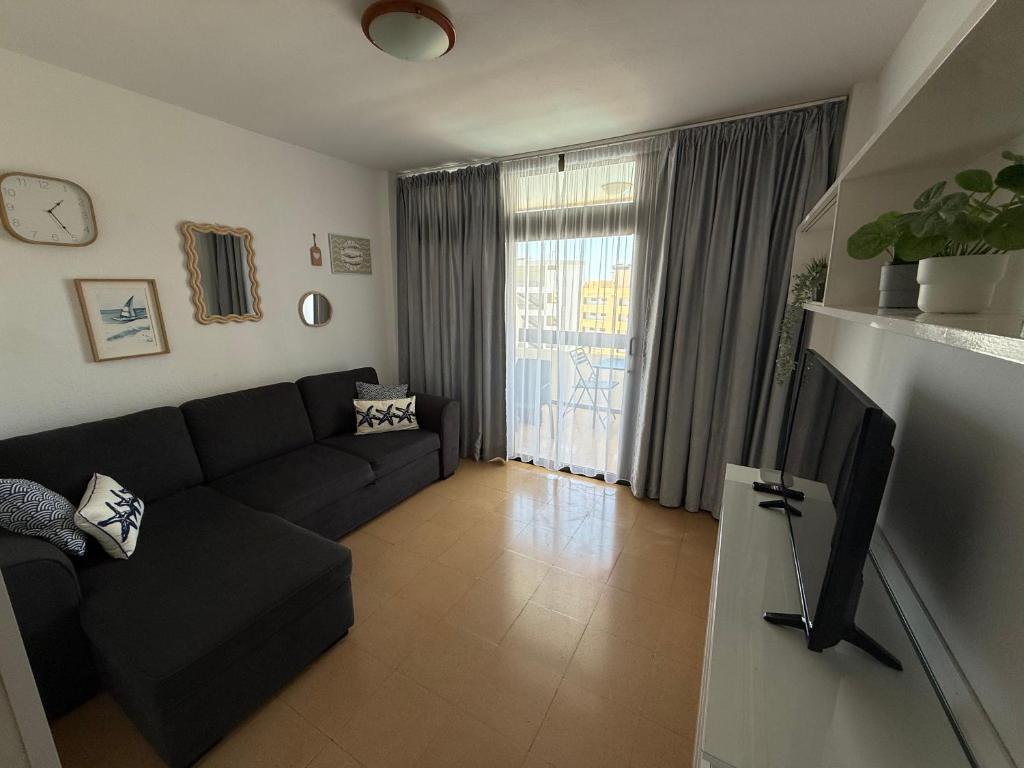 a living room with a couch and a tv at Las Arenas Playa del Ingles Apartment 413 in San Bartolomé