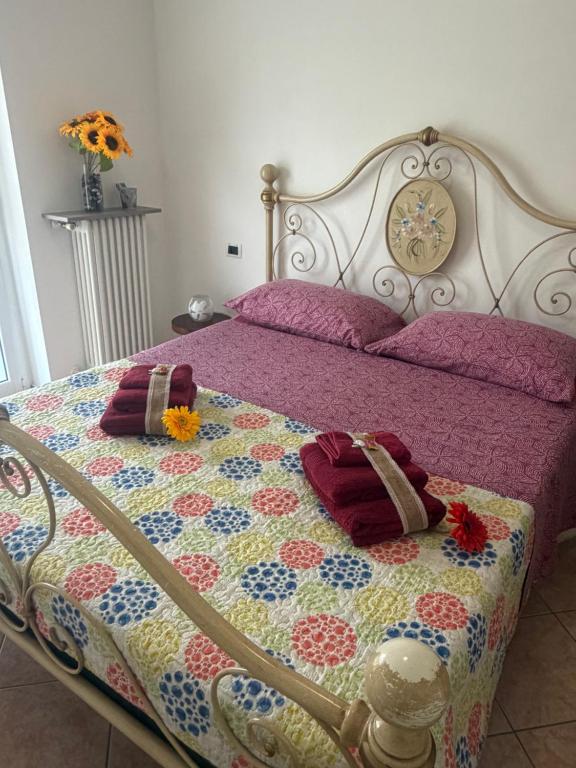 a bed with a quilt and two pillows on it at NORA House in Savona