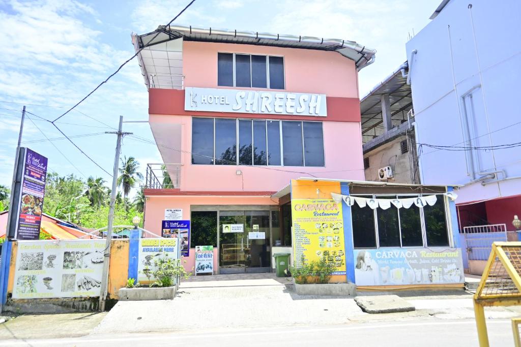 a pink building with a store in front of it at HOTEL SHREESH (NEIL) in Neil Island
