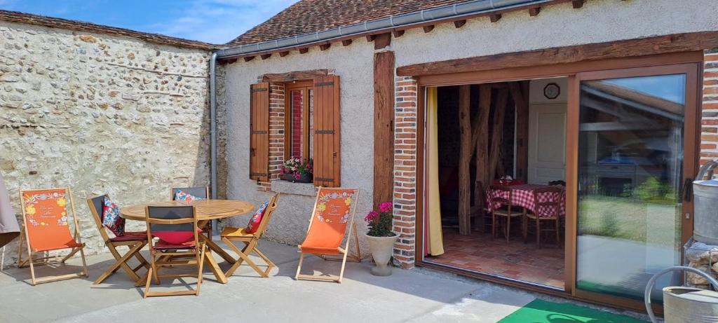 a patio with a table and chairs on a patio at Gîte L'air De Vacances in Bonnée