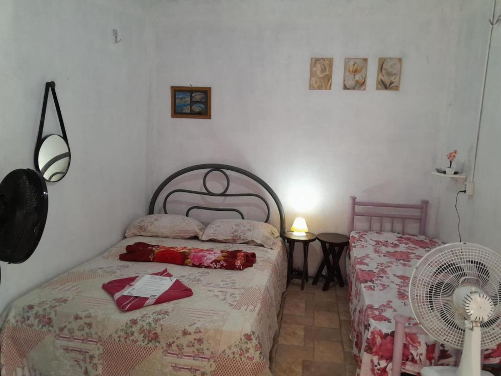a bedroom with two beds and a fan at Hospedagem Chapéu Virado in Belém