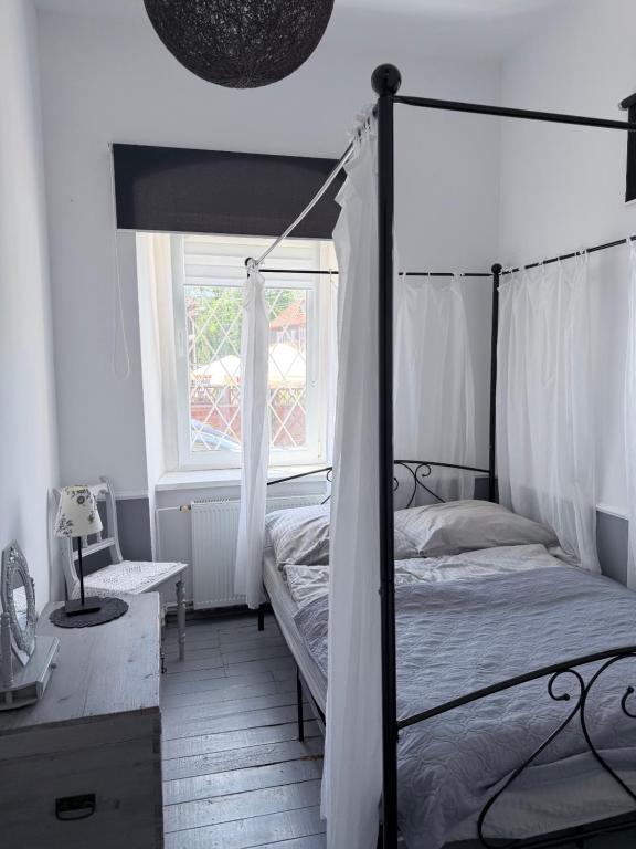 a bedroom with a canopy bed and a window at Sowa Loft in Zagórze Śląskie