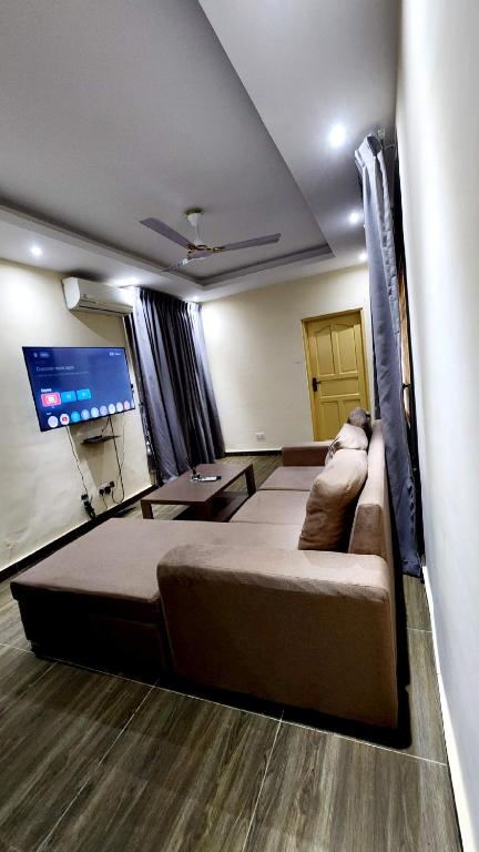 a room with a large bed and a flat screen tv at Executive Deluxe Studio Apt-Osu in Christiansborg