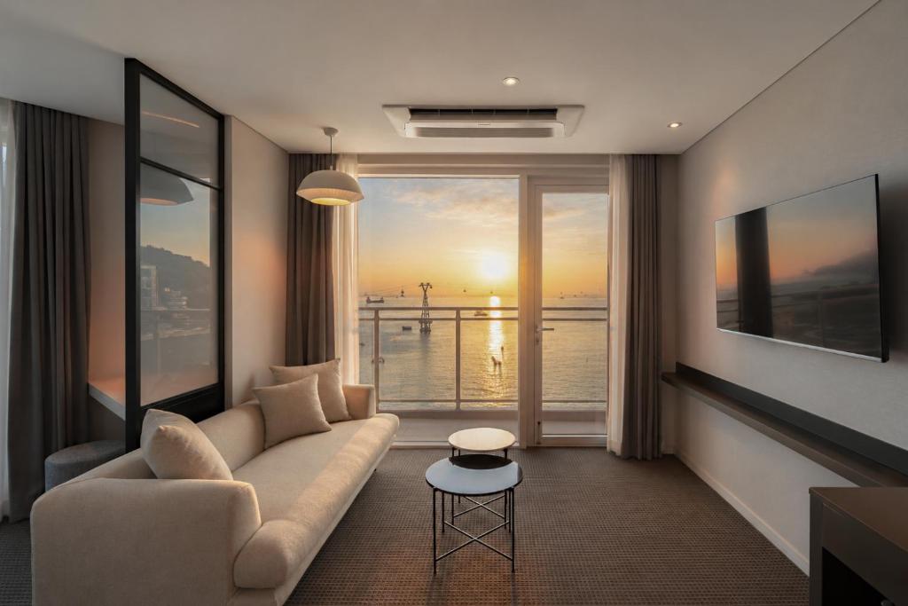 a living room with a couch and a view of the ocean at Urbanstay Busan songdo Beach in Busan