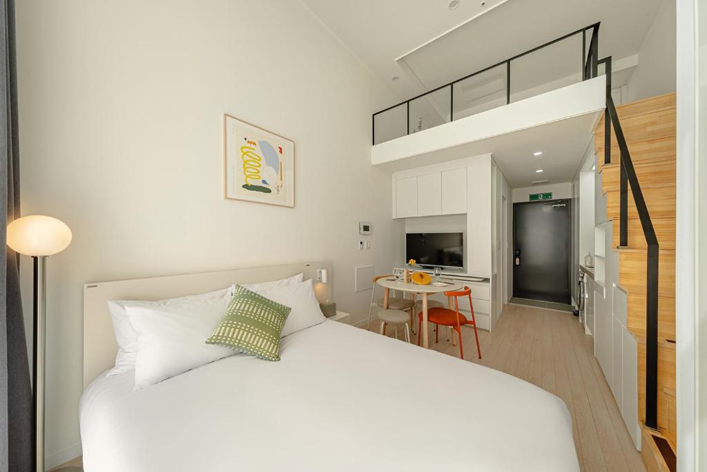 a bedroom with a white bed and a loft bed at Urbanstay Dangjin Terminal in Dangjin
