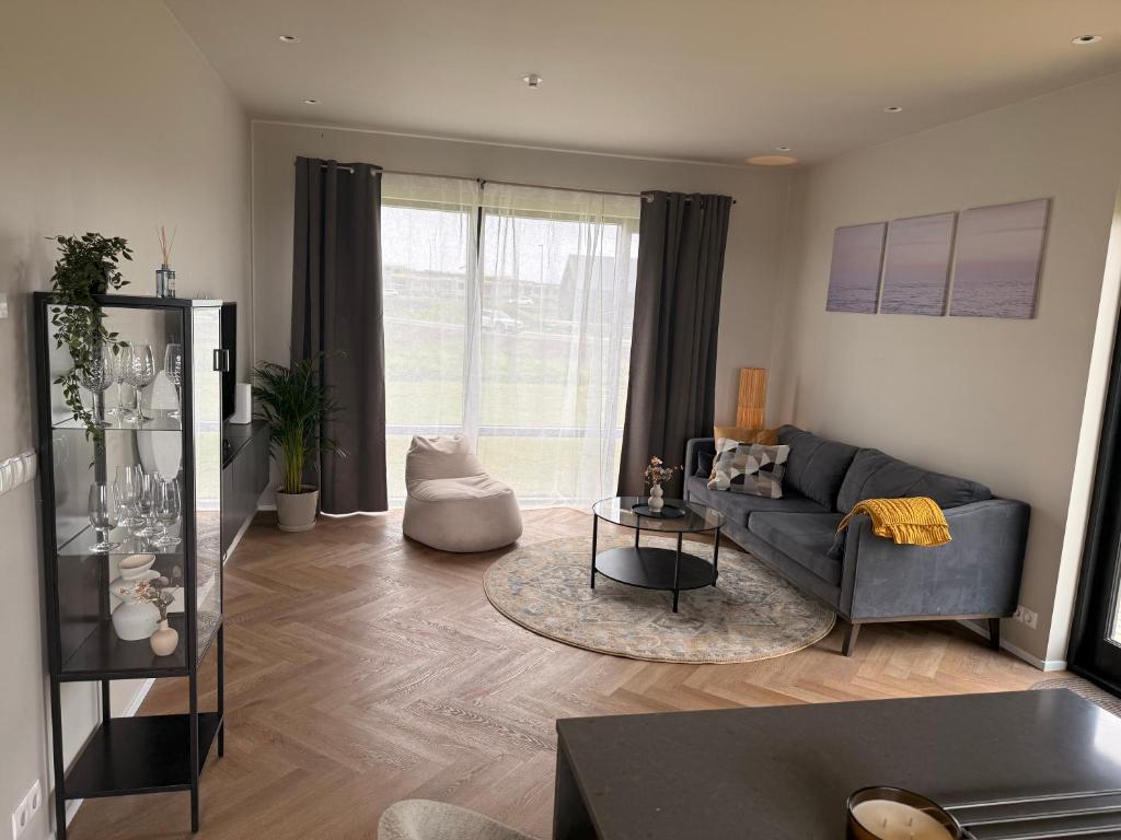 a living room with a couch and a table at ScenicOceanview 4Free parking space 18 mins Downtown in Álftanes