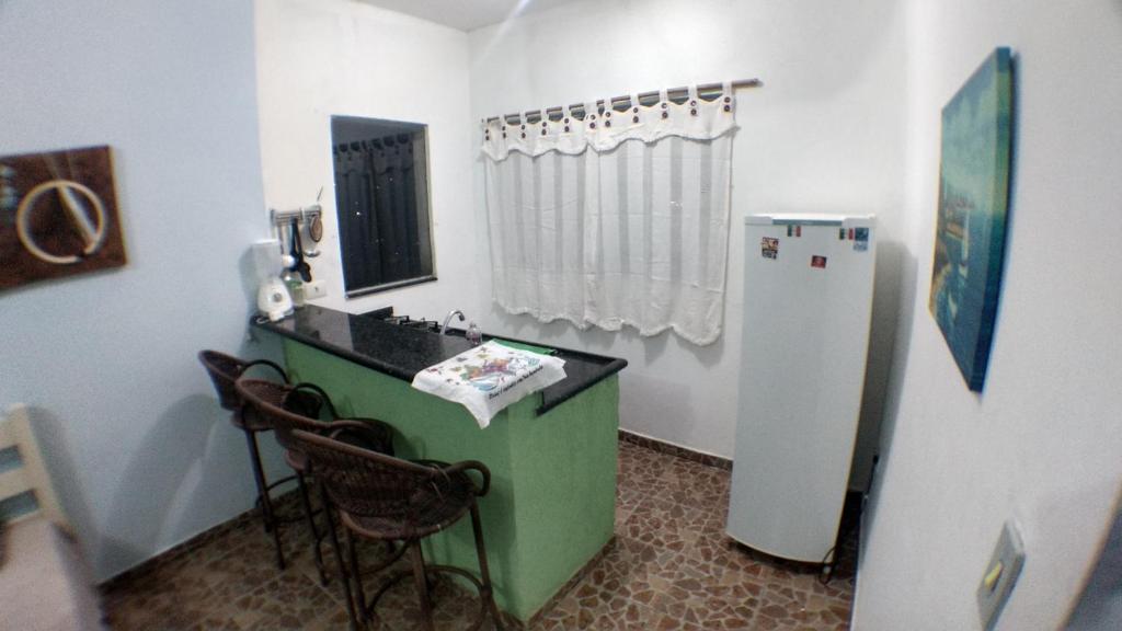 a kitchen with a sink and a refrigerator in a room at Ilha Céu Sol in Ilhabela