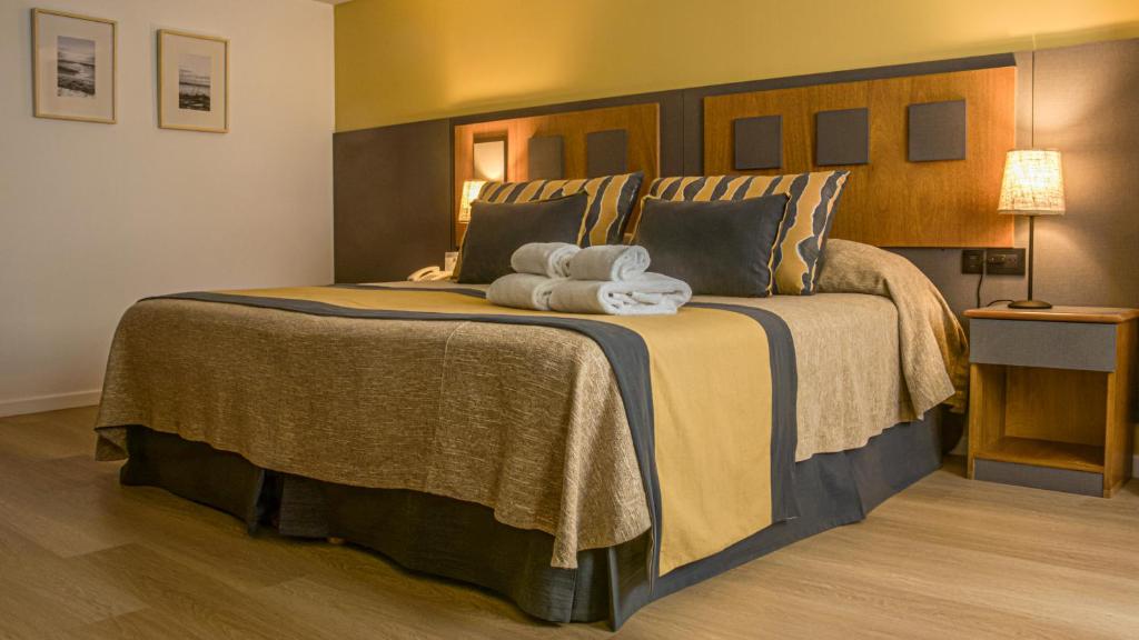 a bedroom with a large bed with two towels on it at Hotel Tronador in Mar del Plata