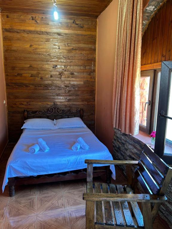 a bedroom with a bed with a wooden wall at Bach-Ana in Ureki