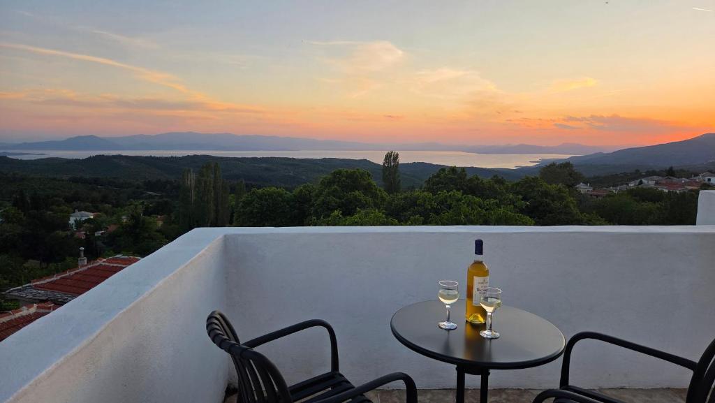 a table with two glasses of wine on a balcony at Holiday Home Neochori Pelion in Neochori