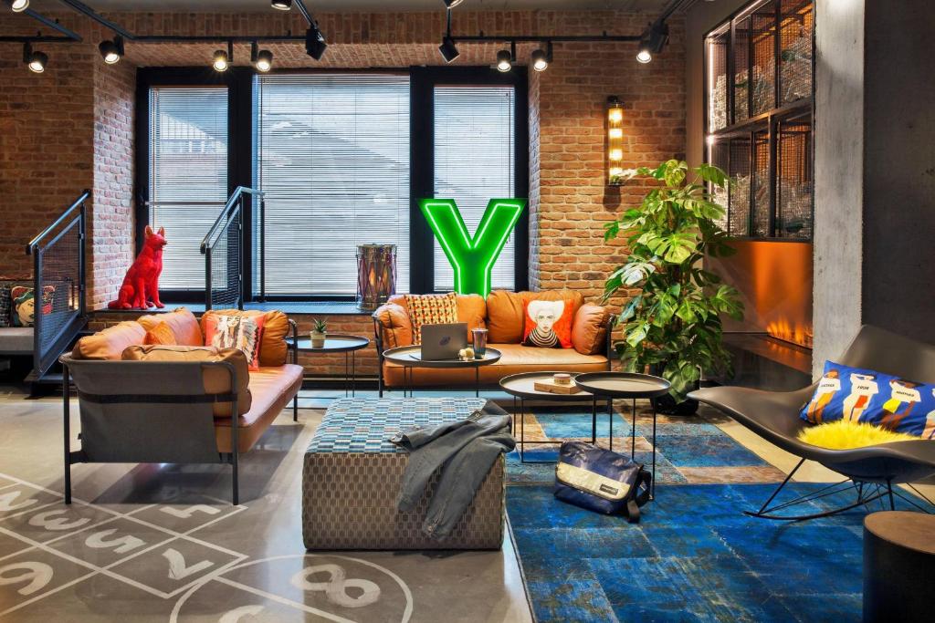 a living room with a couch and a table at Moxy Warsaw Praga in Warsaw