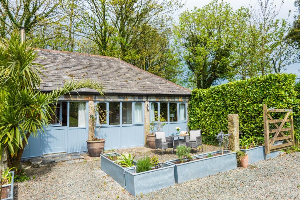 a blue cottage with plants in the garden at The Wagon in Michaelstow