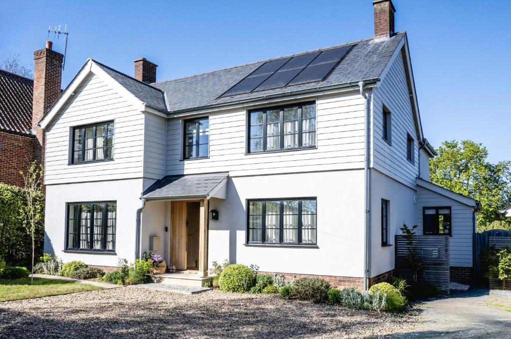 a white house with solar panels on the roof at Hilltop in Woodbridge