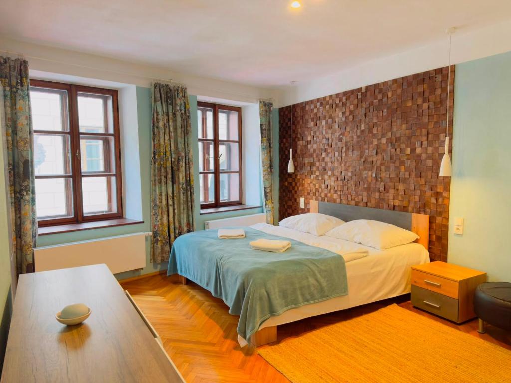 a bedroom with a large bed and two windows at Apartmány 149 u náměstí in Český Krumlov