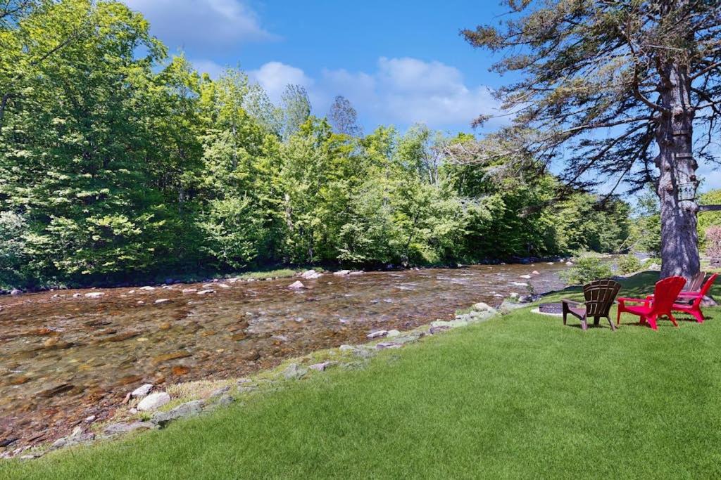 a group of chairs sitting in the grass at Jay Peak Getaway on Trout River in Montgomery
