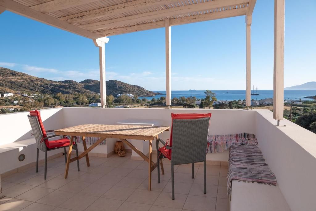 a balcony with a wooden table and chairs at Mylopota Studio I in Mylopotas