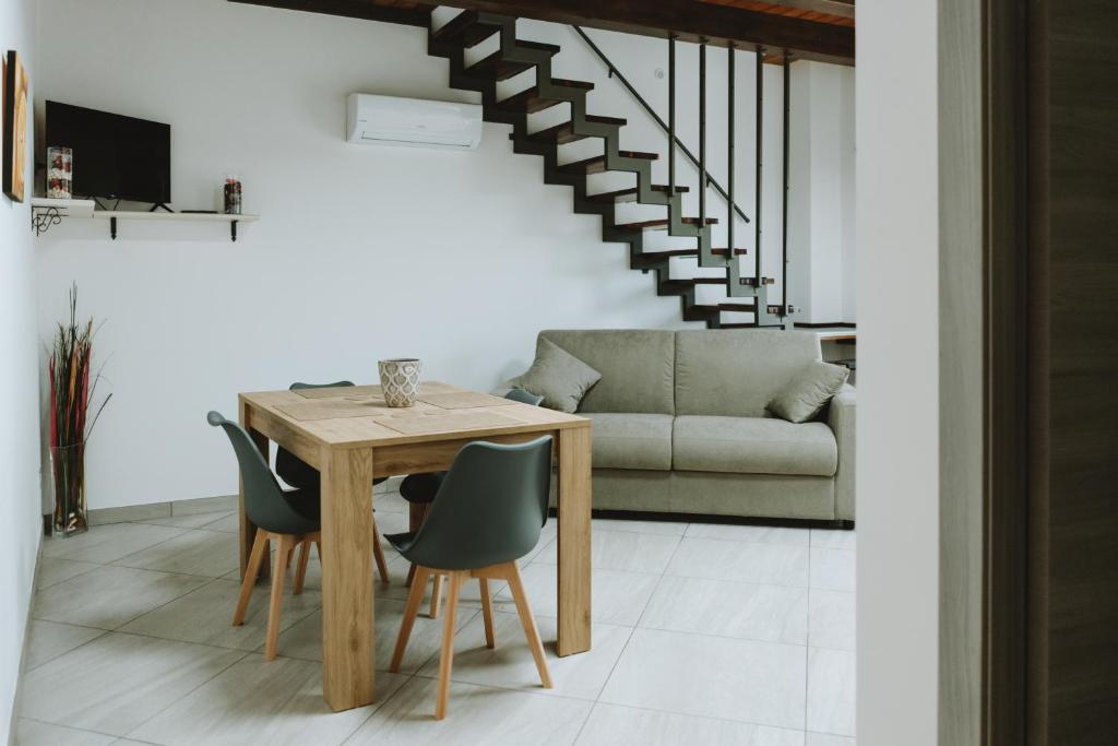 a dining room with a table and chairs and a couch at Aura Residence in San Biagio